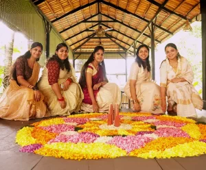 a group of women sitting in front of a flower design